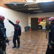 Els bombers asseguren la xapa metàl·lica d’una teulada per a evitar que el vent l’arranque