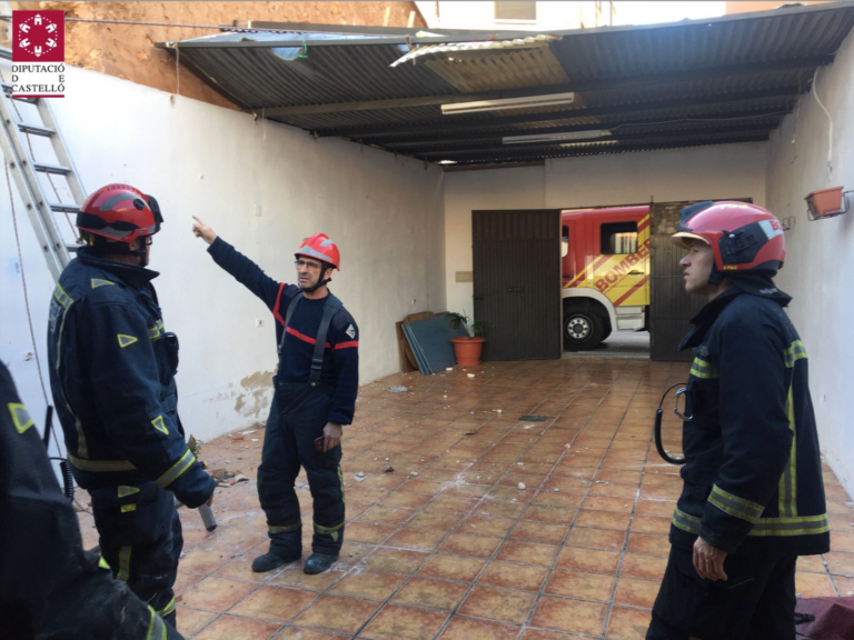 Els bombers asseguren la xapa metàl·lica d’una teulada per a evitar que el vent l’arranque