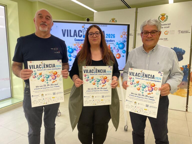 Three people stand indoors, each holding a poster for Vilacència 2026, a youth research competition.