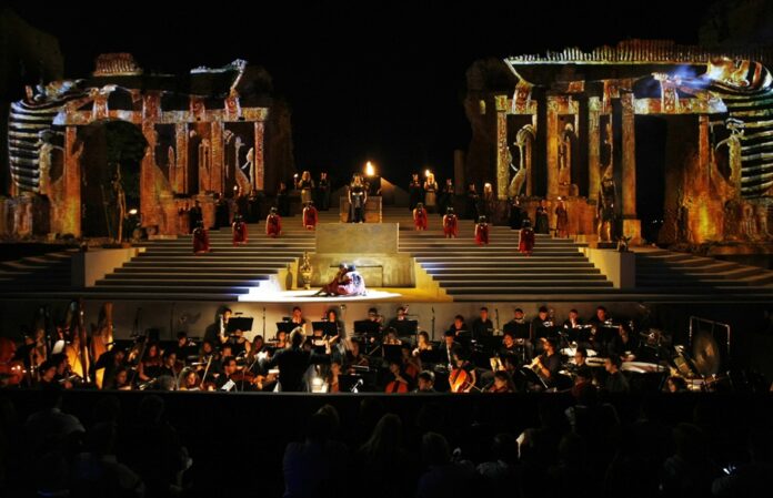Vila-real acollirà el pròxim 23 de juliol la projecció de 'Aida', de Giuseppe Verdi, dins de la quarta edició del festival óh!pera Summer. La producció, considerada una de les versions més espectaculars d'esta òpera filmades a l'aire lliure, es podrà veure als cinemes Sucre, convertint la ciutat en una de les cinc seus de la Comunitat Valenciana que participen en esta iniciativa. La projecció també arribarà a 55 cinemes de 47 localitats d'Espanya i suposa el segon títol del cicle estival després de 'Tosca'. Gravada al Teatre Grec de Taormina, amb les ruïnes de l'antic amfiteatre i el volcà Etna com a escenari natural, esta producció aprofita l'entorn monumental sicilià per a oferir una experiència cinematogràfica singular. La direcció escènica és a càrrec d'Enrico Castiglione, que combina projeccions sobre les ruïnes, efectes visuals i el paisatge mediterrani per a potenciar l'espectacularitat de la representació. El repartiment reunix destacats intèrprets del repertori verdià, amb el tenor Salvatore Licitra en el paper de Radamès, en una de les seues últimes actuacions abans de la seua defunció, fet que conferix a la gravació un valor documental especial. Completen l'elenc la soprano Isabelle Kabatu com a Aida, la mezzosoprano Rossana Rinaldi en el paper d'Amneris i el baríton espanyol Juan Pons com a Amonasro. La direcció musical correspon a Fabio Mastrangelo, al capdavant de l'Orchestra Nazionale dei Conservatori di Musica i del Coro Lirico Francesco Cilea. Amb una duració de 149 minuts i interpretada en italià, 'Aida' narra el conflicte entre l'amor, la lleialtat i el deure, combinant moments de gran espectacularitat, com la Marxa Triomfal, amb un intens drama personal. Després de la projecció d'Aida, el festival óh!pera Summer continuarà amb 'Otello' (6 d'agost), 'Andrea Chénier' (20 d'agost), 'Carmen' (3 de setembre) i 'Nabucco' (17 de setembre), acostant als cinemes produccions dels principals festivals internacionals d'òpera en format Event Cinema.